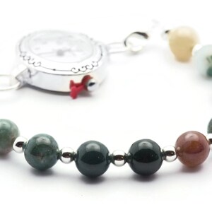 Pode incluir: Um rel&oacute;gio prateado com um mostrador branco e uma pulseira de contas de &aacute;gata verde. A pulseira tem contas prateadas entre cada conta de &aacute;gata.