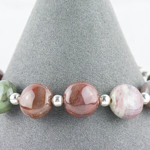 May include: A bracelet made with round, multi-colored agate beads separated by silver spacers.