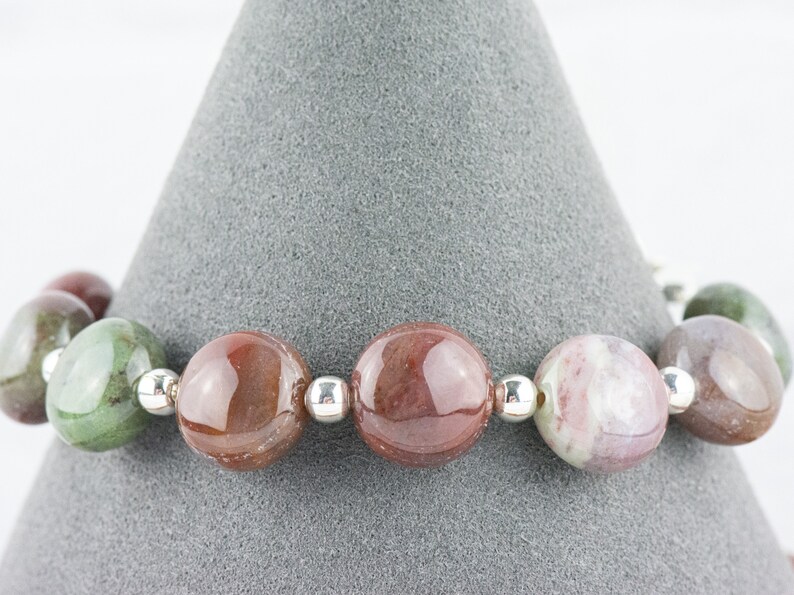 May include: A bracelet made with round, multi-colored agate beads separated by silver spacers.