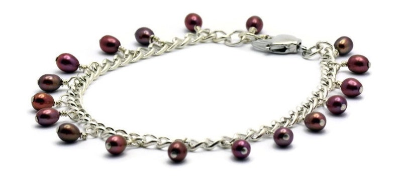 May include: A silver chain bracelet with a lobster clasp and dangling burgundy pearls.