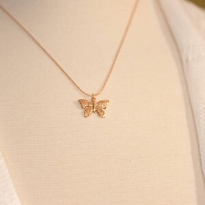 Peut inclure: Un collier en cha&icirc;ne dor&eacute;e avec un pendentif d&eacute;licat en forme de papillon.