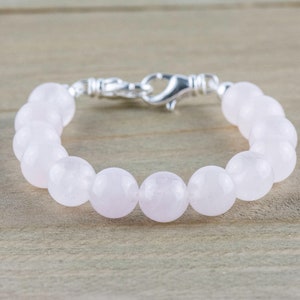 Puede incluir: Un brazalete de cuentas de cuarzo rosa con cierre de plata.