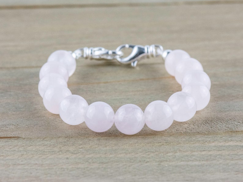 Puede incluir: Un brazalete de cuentas de cuarzo rosa con cierre de plata.