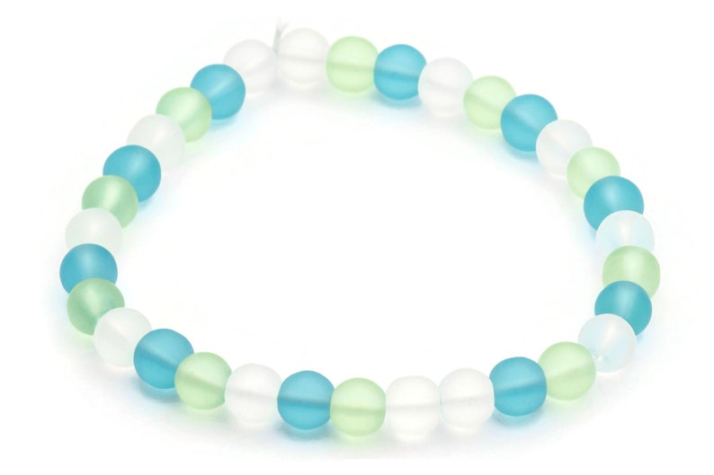 May include: A bracelet made of frosted glass beads in white, light blue, and light green.