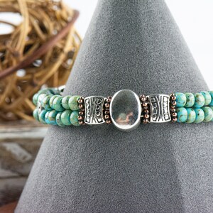 Button and Bows Desert Turquoise Cuff Memory Wire Bracelet displayed on a decorative black bracelet stand.
