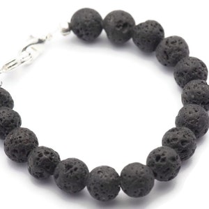 May include: A black lava rock beaded bracelet with a silver clasp.