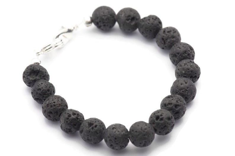 May include: A black lava rock beaded bracelet with a silver clasp.