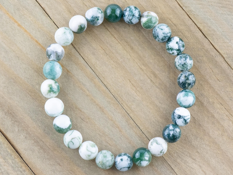 May include: A green and white agate gemstone bracelet with round beads. The bracelet is made of natural stones and has a unique pattern.