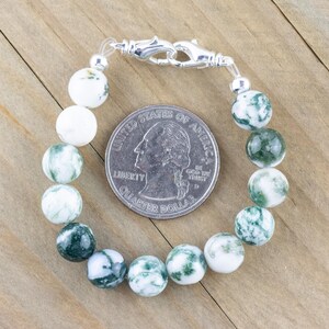 May include: A green and white agate stone bracelet with a silver clasp. The bracelet is about the size of a 25 pence coin.