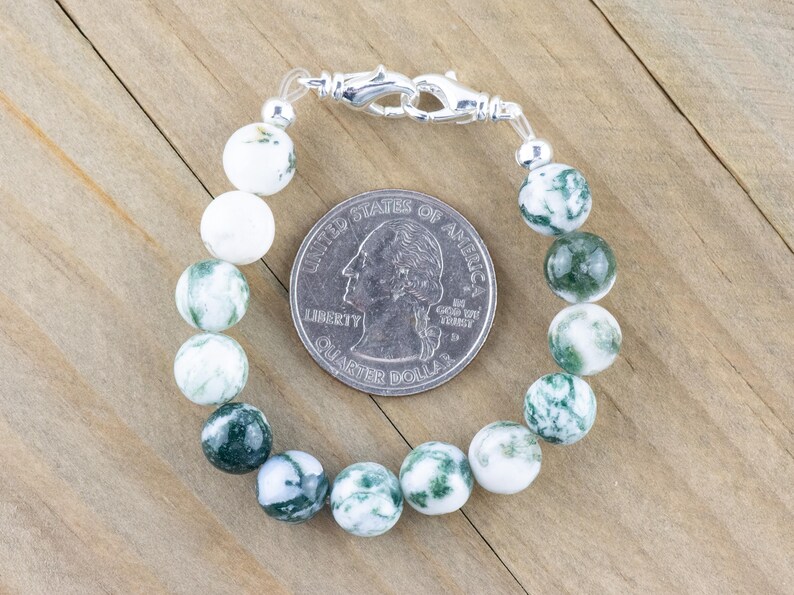 May include: A green and white agate stone bracelet with a silver clasp. The bracelet is about the size of a 25 pence coin.