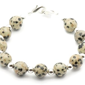 May include: A bracelet made with dalmatian jasper beads and silver accents.