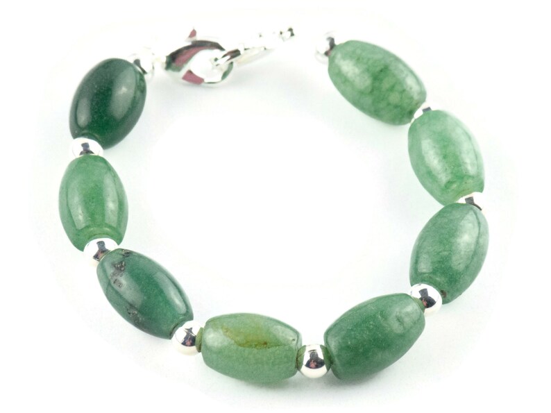 May include: A green jade stone bracelet with silver beads and a clasp.