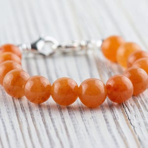 Op de afbeelding: Een armband gemaakt van oranje carneol kralen met een zilveren sluiting.