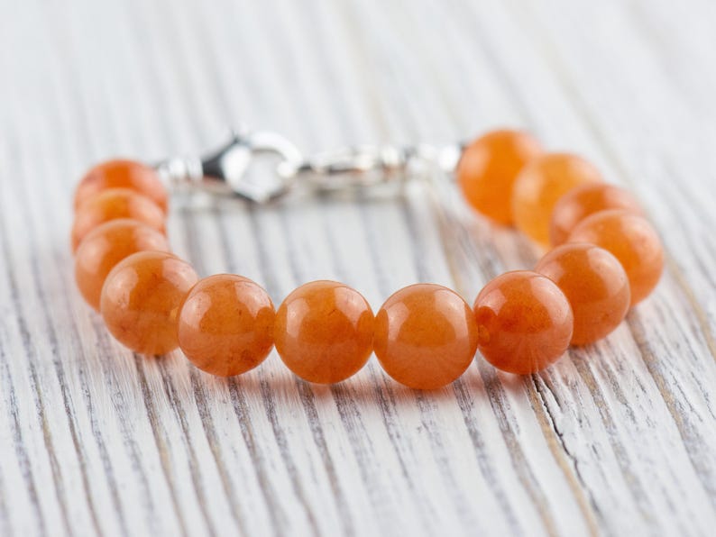 Op de afbeelding: Een armband gemaakt van oranje carneol kralen met een zilveren sluiting.