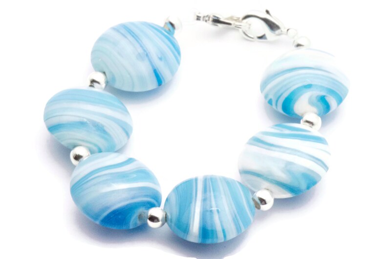 May include: A bracelet made of blue and white swirl glass beads with silver accents.