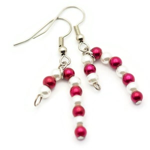 May include: A pair of silver earrings with red and white beads, shaped like candy canes.