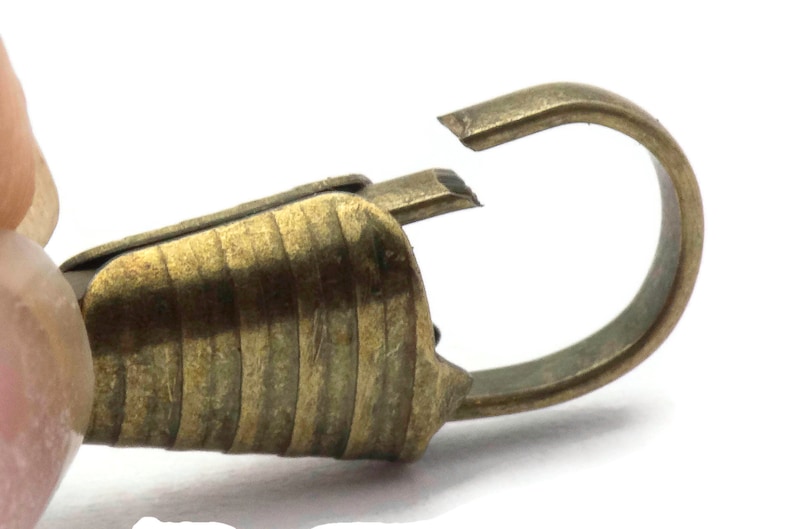 Pode incluir: Um fecho de metal dourado com um design texturizado e estriado. O fecho tem um fecho de gancho e la&ccedil;o.