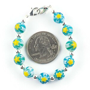 Peut inclure: Un bracelet en argent avec des perles en forme d'&eacute;toile bleues et jaunes. Le bracelet est &agrave; peu pr&egrave;s de la taille d'une pi&egrave;ce de 25 cents am&eacute;ricaine.