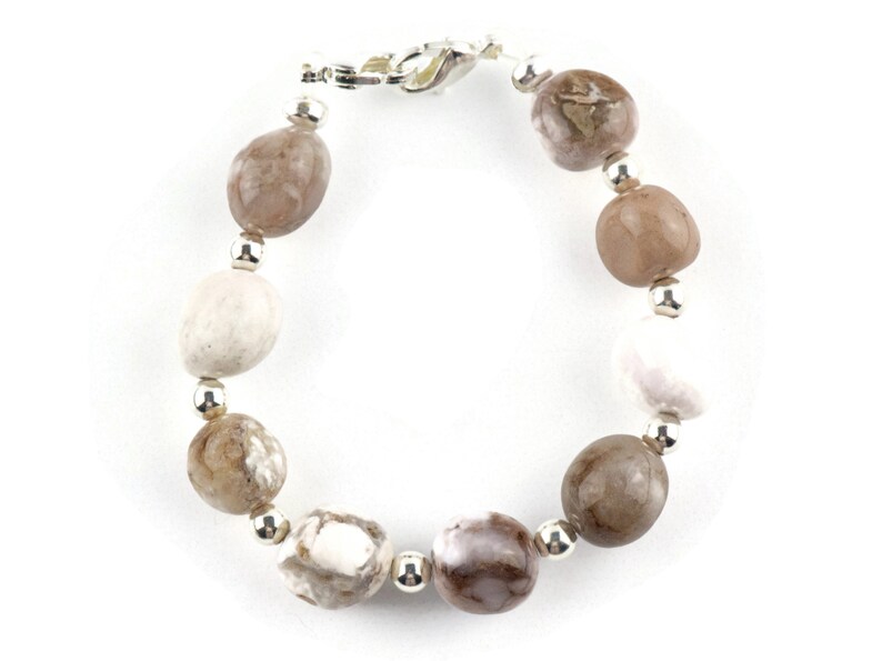 May include: A bracelet made with brown, white, and gray agate beads and silver spacers.
