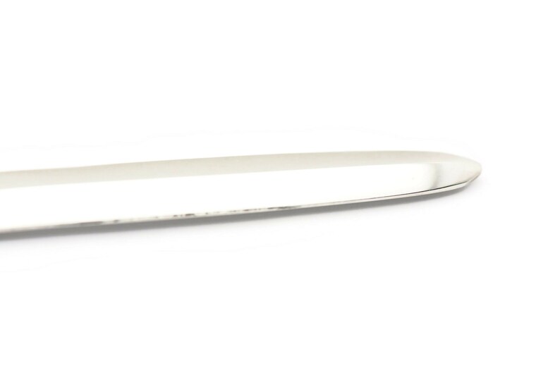 K&ouml;nnte beinhalten: Ein silbernes Buttermesser mit abgerundeter Spitze und einer glatten, polierten Oberfl&auml;che.