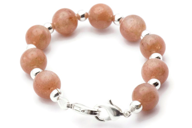 May include: A bracelet with a silver clasp and round, light brown beads.