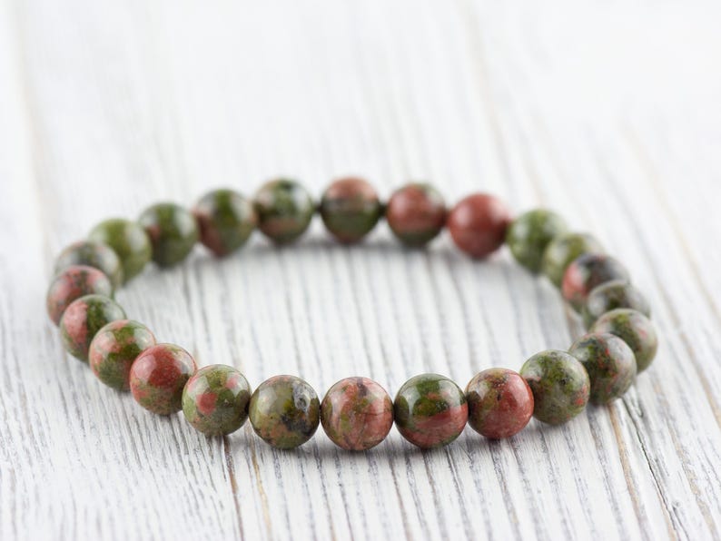 May include: A green and red speckled stone bracelet with round beads.