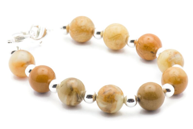 May include: A bracelet made with brown and beige agate beads and silver spacers.