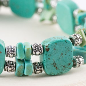 Op de afbeelding: Een turquoise en zilveren armband met vierkante turquoise kralen en zilveren spacer kralen.