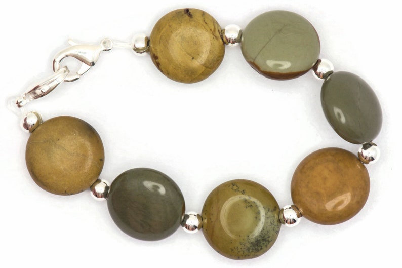 May include: A bracelet made with round, green and brown jasper stones and silver beads. The bracelet has a silver clasp.