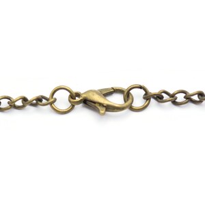 May include: A close-up of a gold-toned chain with a lobster clasp.