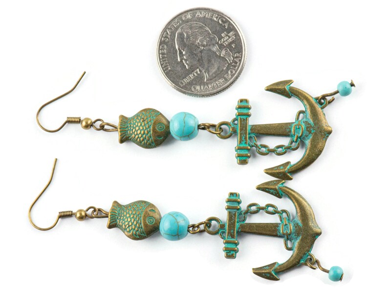 Puede incluir: Un par de pendientes largos de color turquesa y bronce con un dije de pez, una cuenta turquesa y un dije de ancla. Los pendientes miden aproximadamente 7,5 cm de largo.