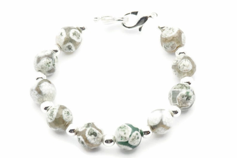 Op de afbeelding: Een zilveren armband met groene en witte agaat kralen.