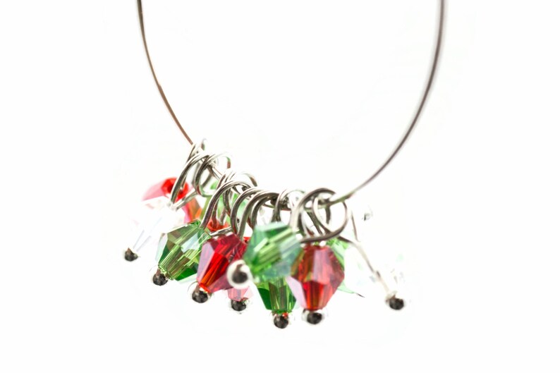 May include: A silver ring with a series of red and green crystal beads attached to it. The beads are arranged in a cluster and hang from the ring.