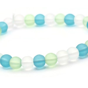 May include: A bracelet made of frosted glass beads in shades of blue, green, and white.