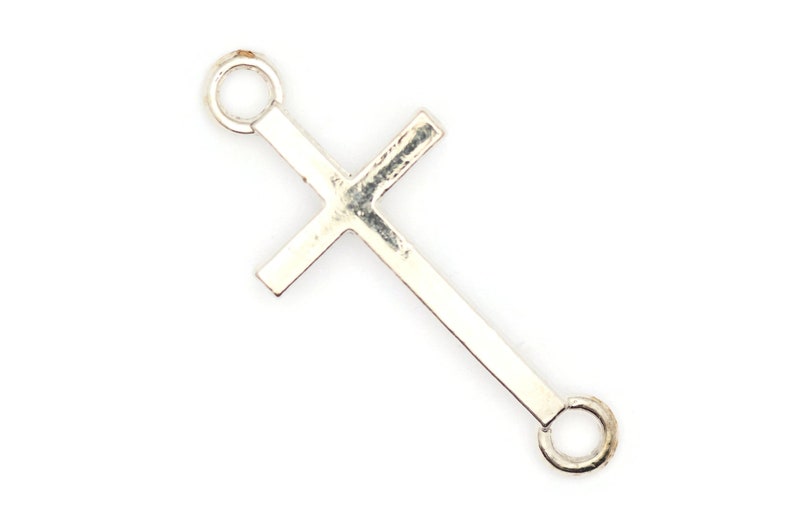 May include: Silver-toned cross charm with two jump rings for attaching to jewelry or other crafts.