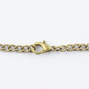 May include: A close-up of a gold chain with a lobster clasp.