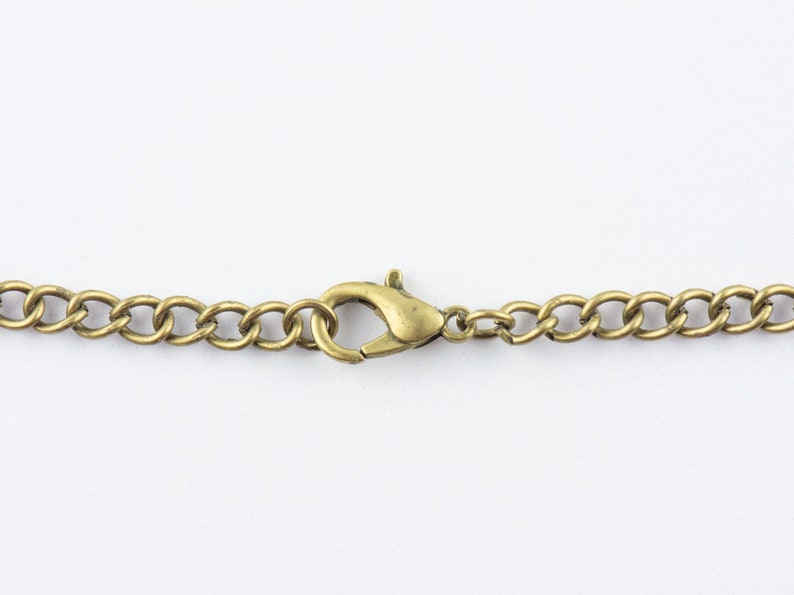 May include: A close-up of a gold chain with a lobster clasp.