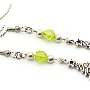 May include: A pair of silver earrings with green glass beads and silver Christmas tree charms.