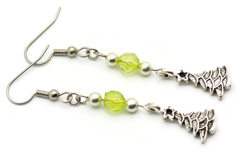 May include: A pair of silver earrings with green glass beads and silver Christmas tree charms.