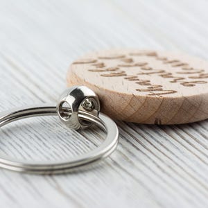 May include: A wooden keychain with a silver ring and the text "You are my sunshine" engraved on the front.