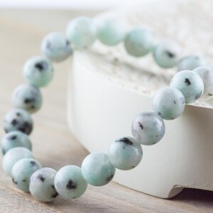 Puede incluir: Un brazalete hecho de cuentas de color azul claro y blanco con motas. El brazalete est&aacute; hecho de piedra natural y es una pieza de joyer&iacute;a hermosa y &uacute;nica.