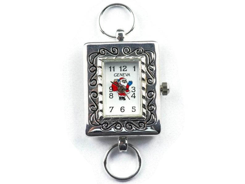 May include: Silver pocket watch with a Santa Claus design on the face. The watch face reads "GENEVA" and has Roman numeral hour markers.