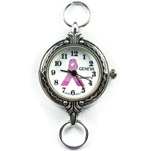 K&ouml;nnte beinhalten: Eine silberne Taschenuhr mit wei&szlig;em Zifferblatt und einem rosafarbenen Schleifendesign. Das Zifferblatt der Uhr zeigt "GENEVA QUARTZ" und hat schwarze Zeiger. Die Uhr hat eine silberne Kette mit einem Ring oben.