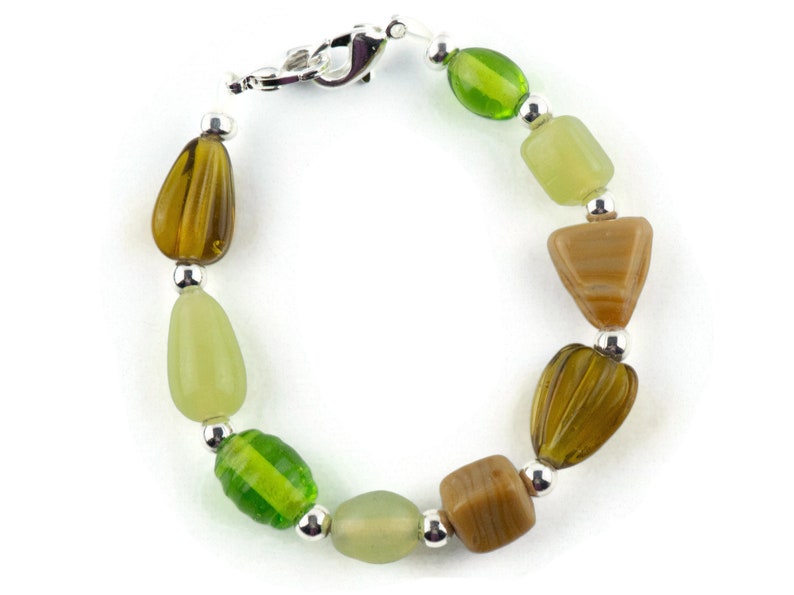 May include: A green, brown and silver beaded bracelet with a silver clasp.