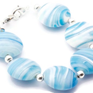May include: A bracelet made of blue and white swirled glass beads with silver accents.