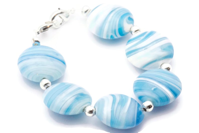 May include: A bracelet made of blue and white swirled glass beads with silver accents.