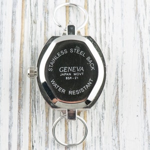 Pu&ograve; includere: Il retro di un orologio argentato con un quadrante rotondo e un fondello in acciaio inossidabile. L'orologio ha un movimento Geneva Japan Movt BSR-21 ed &egrave; resistente all'acqua.