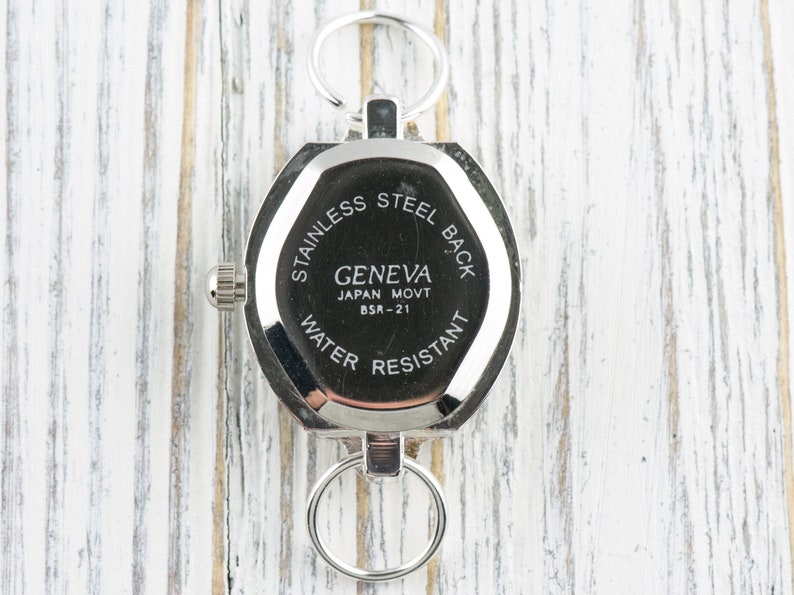 Pu&ograve; includere: Il retro di un orologio argentato con un quadrante rotondo e un fondello in acciaio inossidabile. L'orologio ha un movimento Geneva Japan Movt BSR-21 ed &egrave; resistente all'acqua.