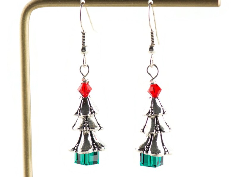 May include: Silver Christmas tree earrings with red and green crystal accents.