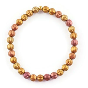 May include: A gold and copper toned beaded bracelet with a gold clasp.
